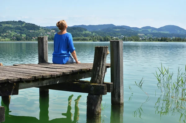 Flicka på trä bryggan. Schweiz — Stockfoto