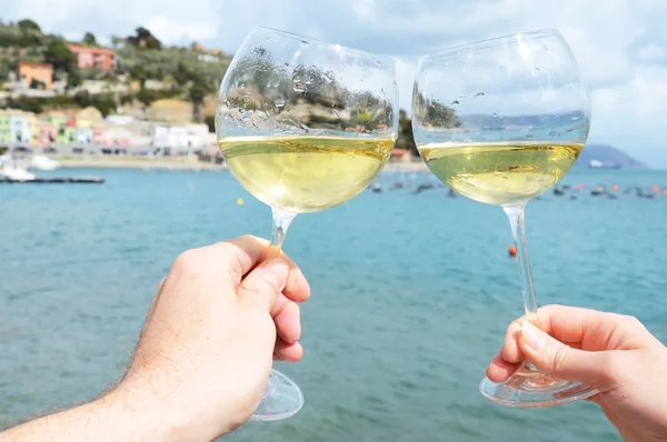 Two wineglasses in the hands against the harbour of Portvenere, — Stock Photo, Image