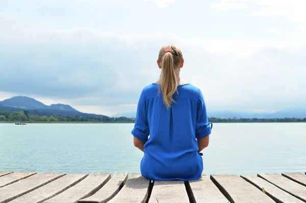 Girl on the wooden jetty. Switzerland — Stock Photo, Image