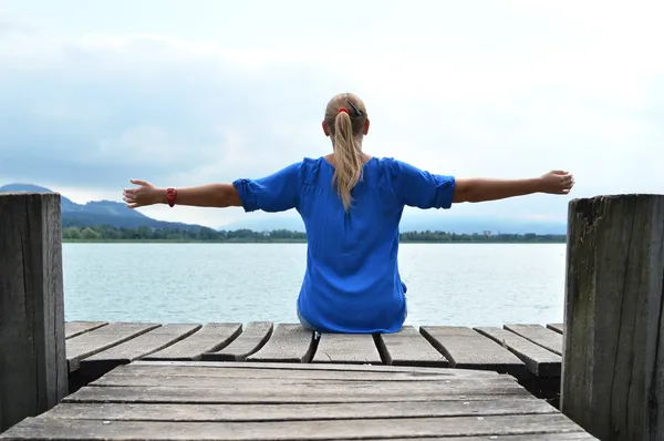 Girl on the wooden jetty. Switzerland — Stock Photo, Image