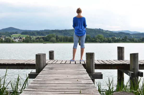 Girl on the wooden jetty — Stock Photo, Image