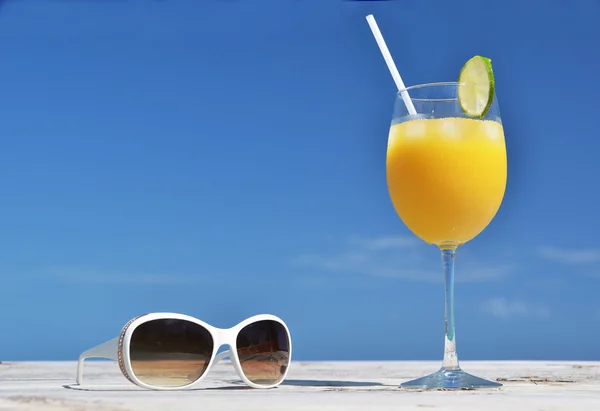 Jugo de naranja y gafas de sol . — Foto de Stock