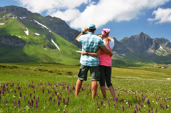 Travelers in an Alpine meadow. Melchsee-Frutt, Switzerland — Stock Photo, Image