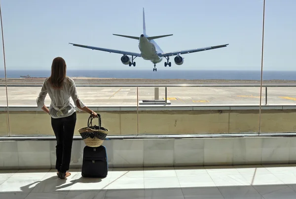 Ragazza alla finestra dell'aeroporto guardando l'oceano — Foto Stock