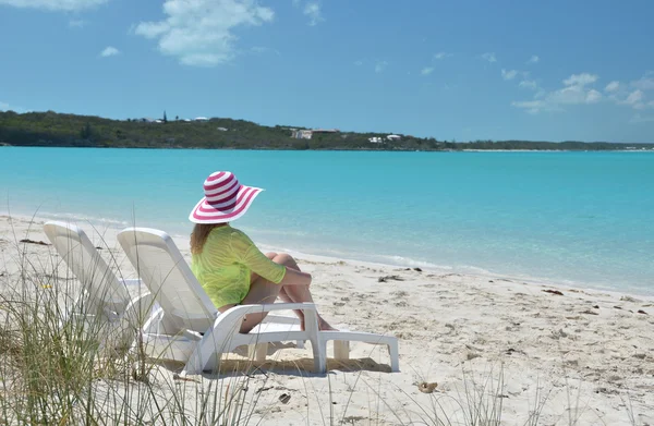 Chica con un sombrero a rayas en la playa de Exuma, Bahamas — Foto de Stock