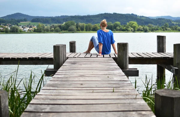 Girl on the wooden jetty — Stock Photo, Image