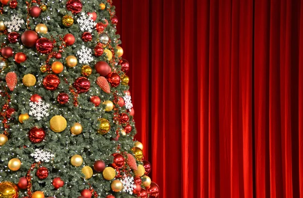 Christmas tree against red drapery — Stock Photo, Image