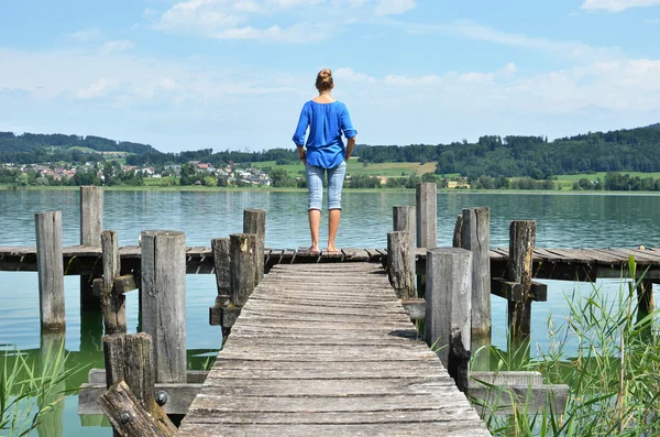 Flicka på trä bryggan. Schweiz — Stockfoto