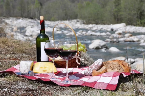 Vino rosso, formaggio e uva serviti a un picnic . — Foto Stock