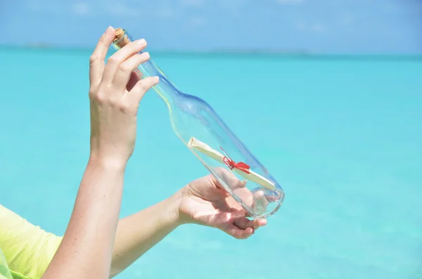 Bottle with a message in the hands — Stock Photo, Image