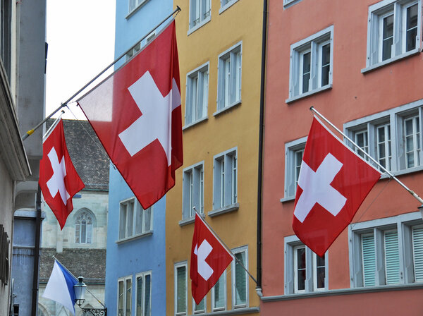 Old street in Zurich decorated with flags for the Swiss National Day