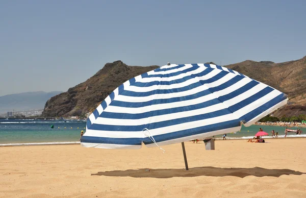 Gestreifter Sonnenschirm am Strand — Stockfoto