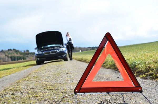 Trojúhelník dopravní značka a auto — Stock fotografie