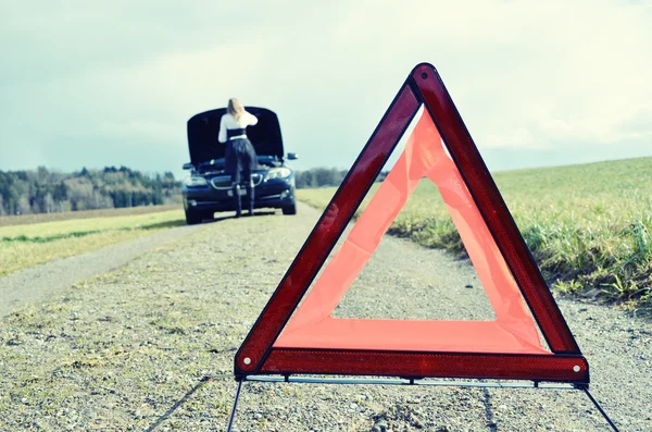 Girl and warning triangle — Stock Photo, Image