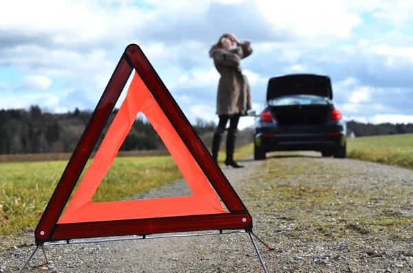 Uszkodzony samochód, dziewczyna i trójkąt ostrzegawczy — Zdjęcie stockowe