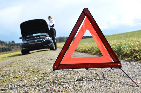 Rozbité auto, dívka a výstražný trojúhelník — Stock fotografie