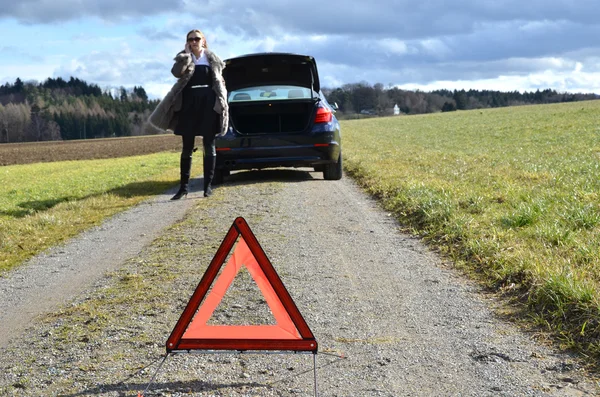 Kırık araba, kız ve uyarı üçgeni — Stok fotoğraf