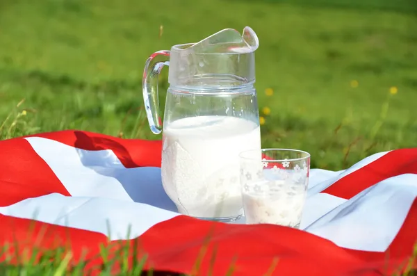 Caraffa di latte sulla bandiera svizzera . — Foto Stock