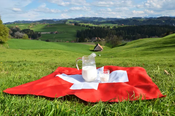 Pot de lait sur le drapeau suisse . — Photo