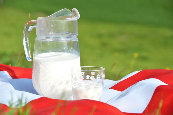 Jug of milk on the Swiss flag — Stock Photo, Image