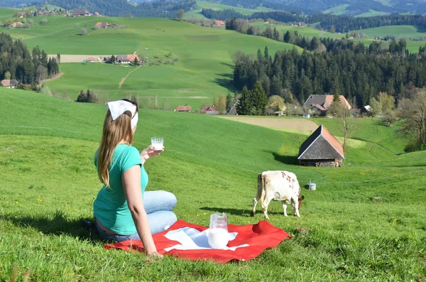 Woman with Jug of milk on the Swiss flag — Stock Photo, Image