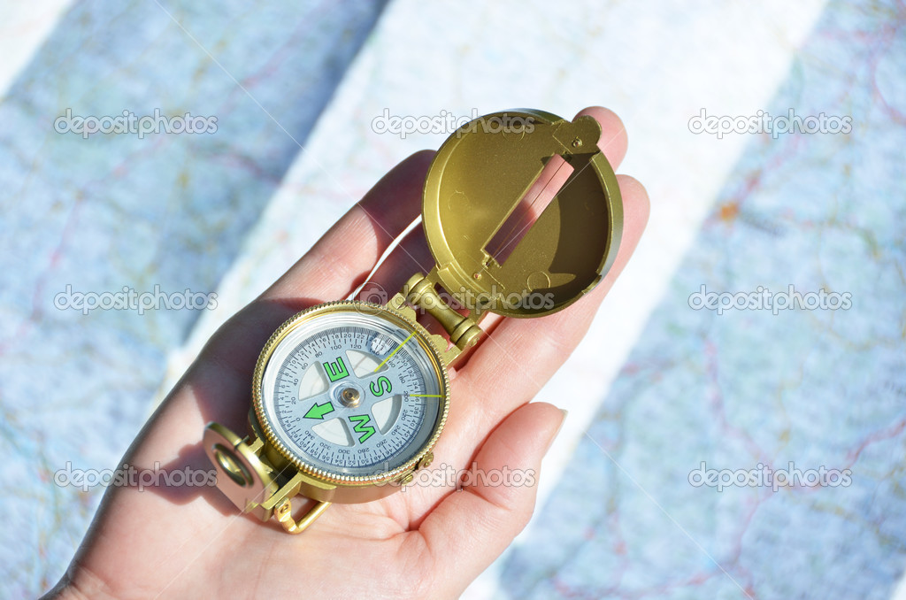 Compass in the hand against a map