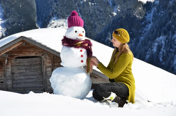 女の子は雪だるまの装飾 — ストック写真