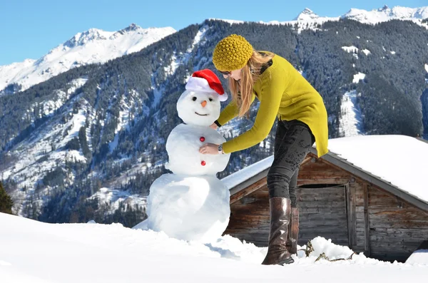 Tjej dekorera en snögubbe — Stockfoto