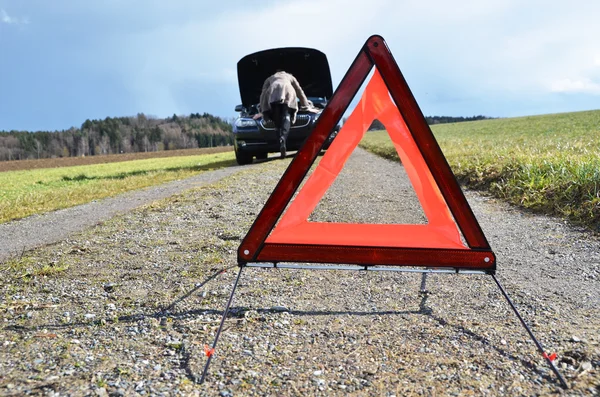 Rozbité auto, dívka a výstražný trojúhelník — Stock fotografie