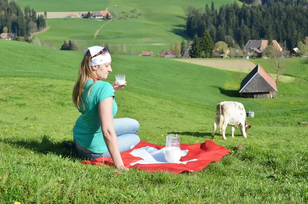 Jarra de leche en la bandera suiza — Foto de Stock