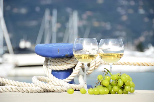 Wineglasses and grapes on the yacht pier — Stock Photo, Image