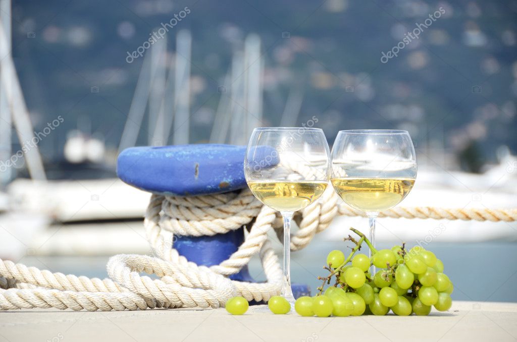 Wineglasses and grapes on the yacht pier