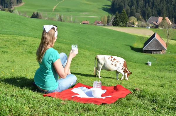 Kruik van melk op Zwitserse vlag. — Stockfoto