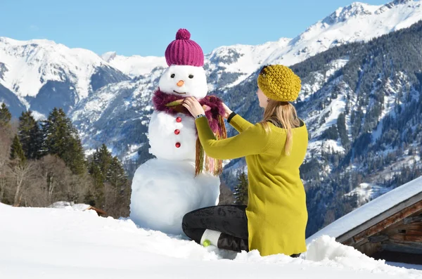 女の子は雪だるまの装飾 — ストック写真