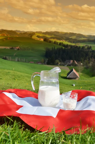 Caraffa di latte sulla bandiera svizzera . — Foto Stock
