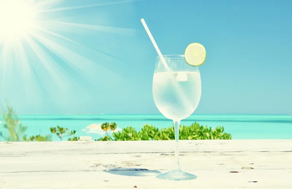 Vaso de agua en la playa tropical — Foto de Stock