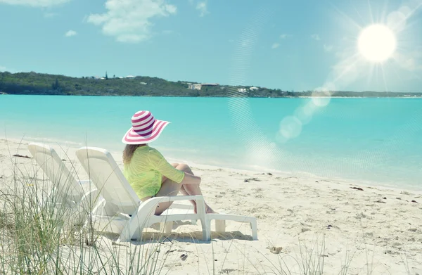 Meisje in een gestreepte muts op het strand — Stockfoto