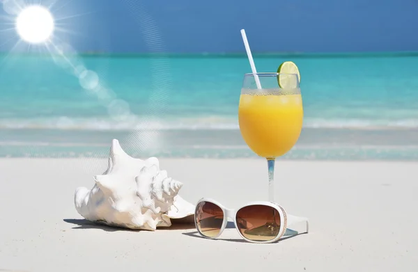 Sok pomarańczowy i okulary przeciwsłoneczne na plaży. Exuma, Bahamy — Zdjęcie stockowe