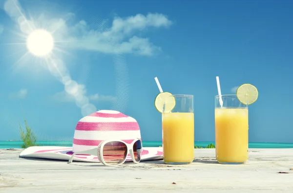 Óculos de sol, chapéu e suco de laranja — Fotografia de Stock