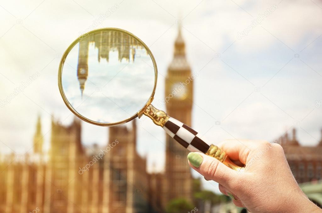 Magnifying glass in the hand against Big Ben