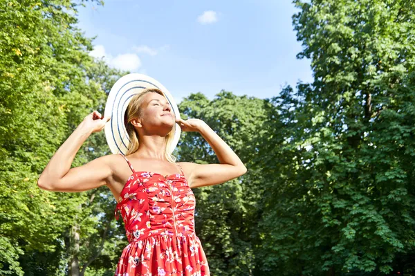 Belle jeune femme avec chapeau dans le parc avec un grand sourire sensuel — Photo