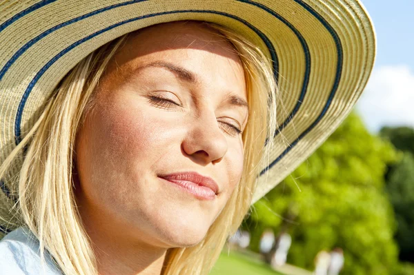 Portret van mooie jonge vrouw met hoed in park met grote joyf — Stockfoto