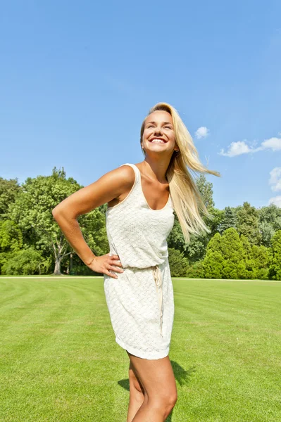 Mooie jonge vrouw in park met grote joyfull smile over de sk — Stockfoto