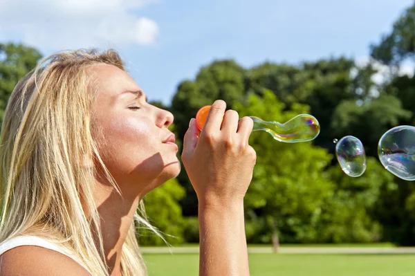 Donna nel parco giocare in tazza bubles sul verde — Foto Stock