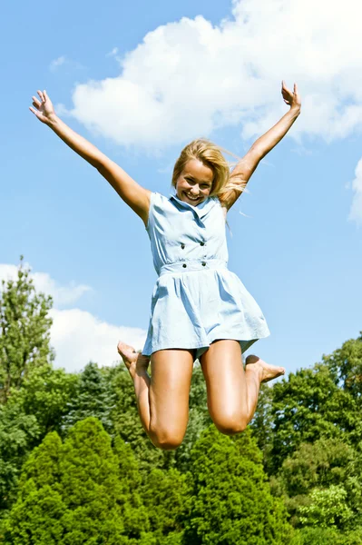 Hermosa mujer joven saltar al cielo en el parque Fotos De Stock Sin Royalties Gratis