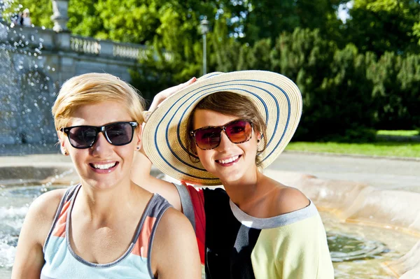 大きな笑みを浮かべて旅行 2 つの女性と sideseeing 屋外の噴水 — ストック写真