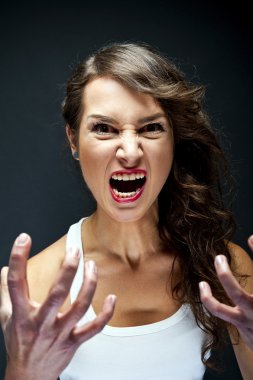 Angry woman on black background