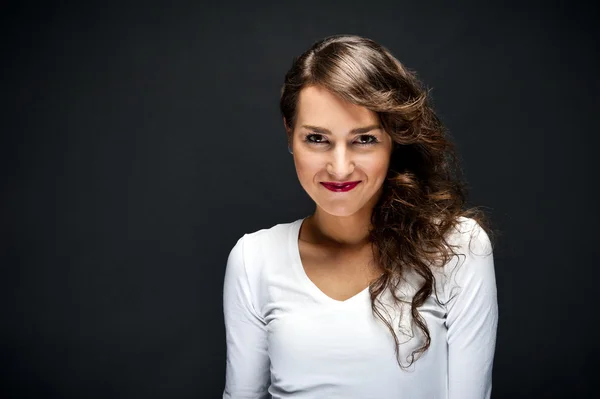 Mujer con sonrisa sensual sobre fondo negro — Foto de Stock