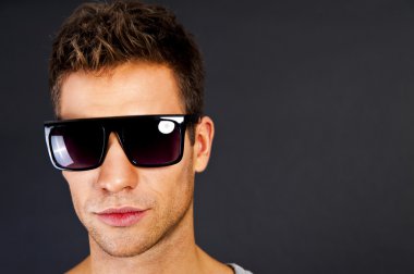 gülümseme ve güneş gözlüğü gri tank top yakışıklı adam