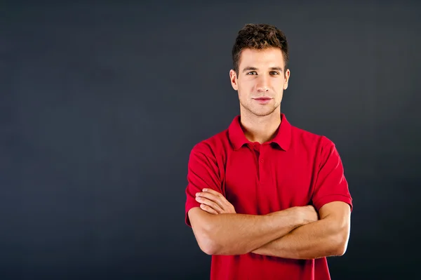 Man op zwarte achtergrond met rode shirt met glimlach — Stockfoto